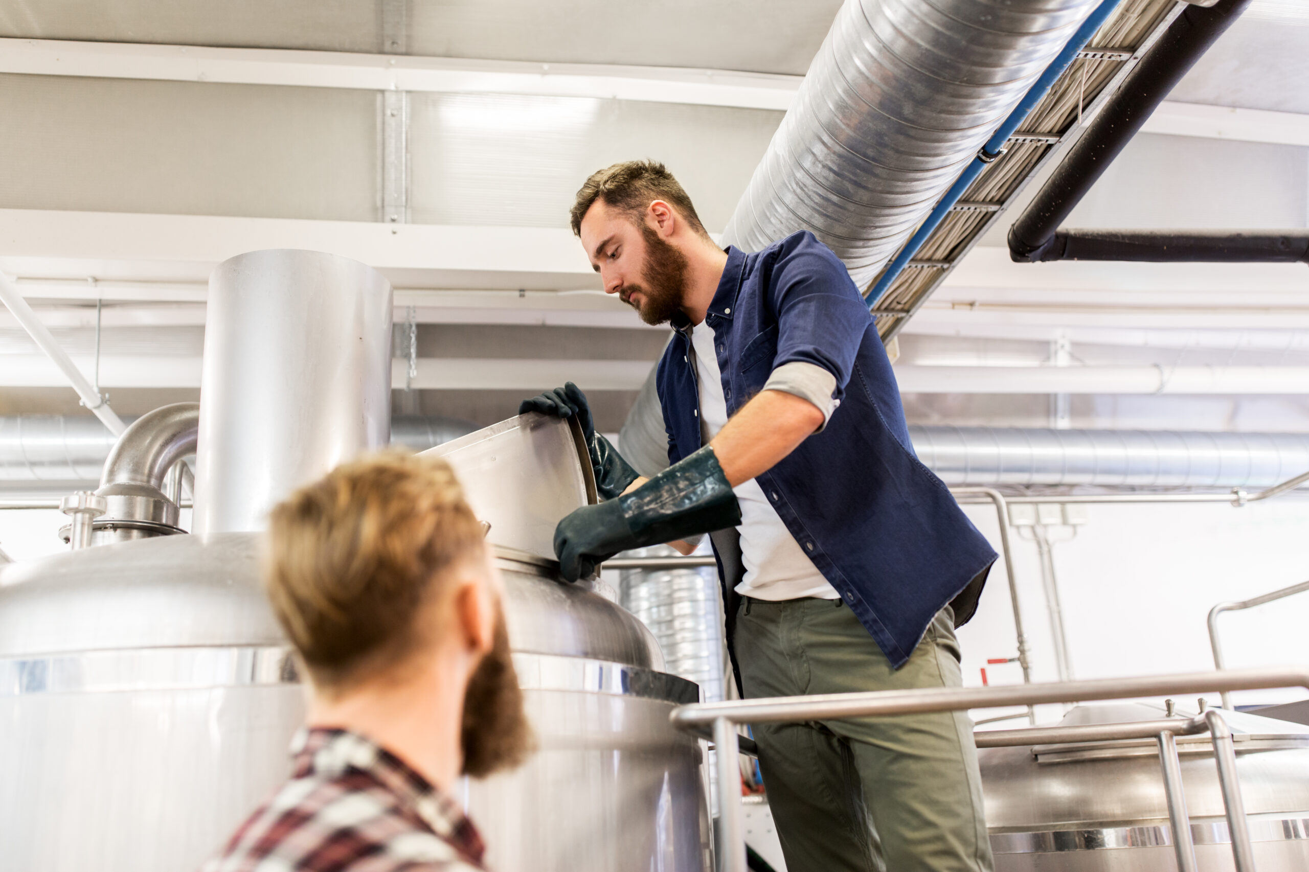 manufacture, business and people concept - men working at craft brewery or beer plant