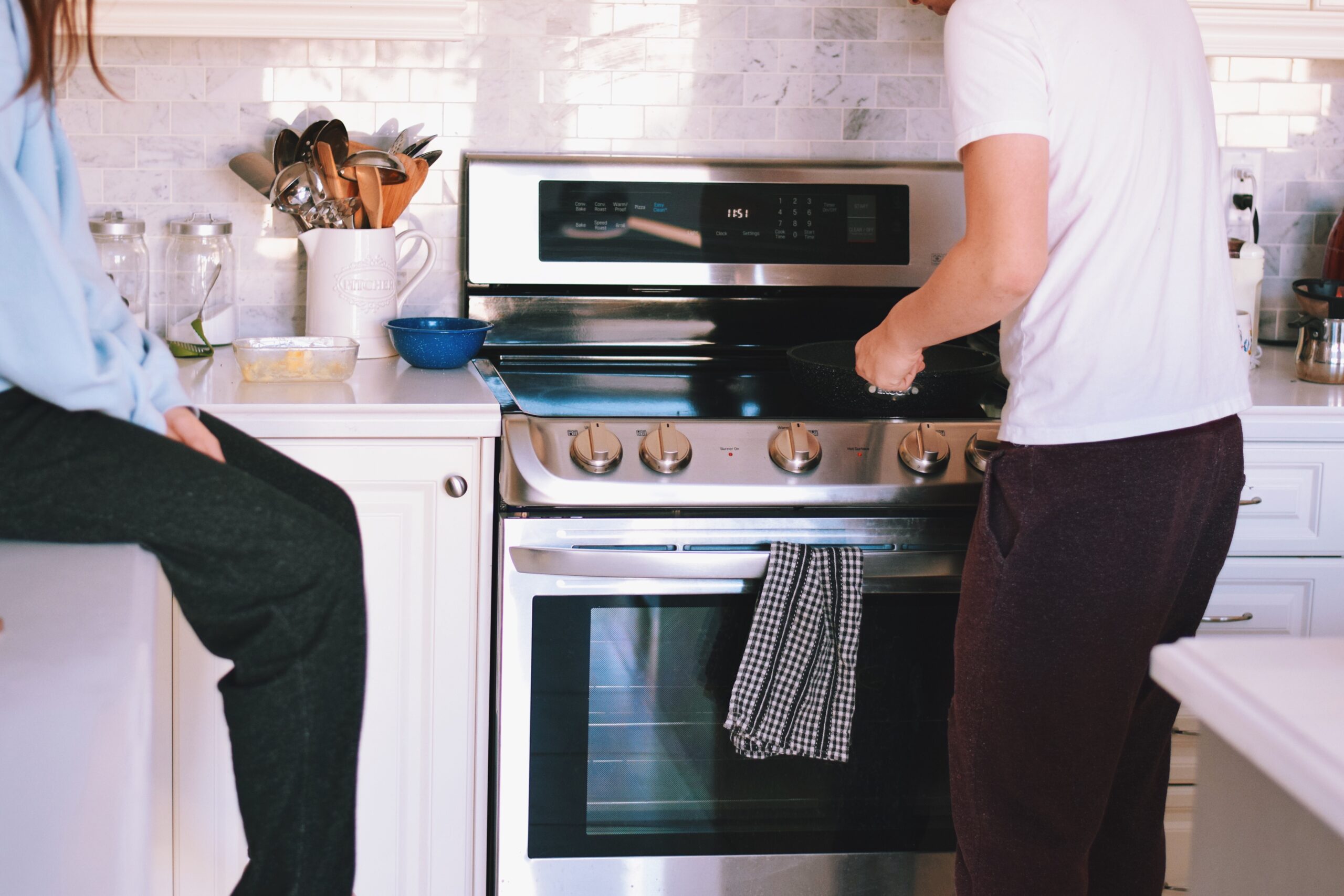 young-man-cooking-while-a-young-girl-sitting-on-a-2025-03-12-21-43-05-utc